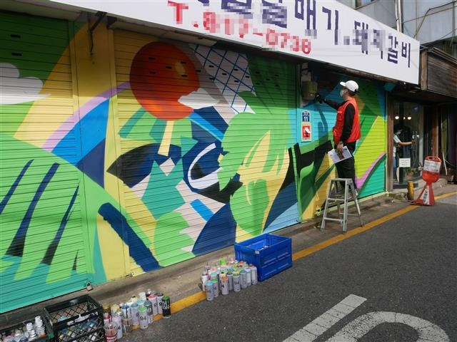 서울 동작구 흑석동 ‘흑리단길’에서 그래피티 작가 유승백씨가 벽화 작업을 하고 있다. 동작구 제공