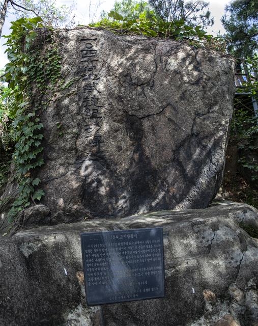 서울미래유산으로 지정된 1982년 건립 전적비와 1958년에 세운 자연석 전적비. 옛 전적비는 표지판도 없이 데크 계단 아래 감추듯 숨어 있었다.