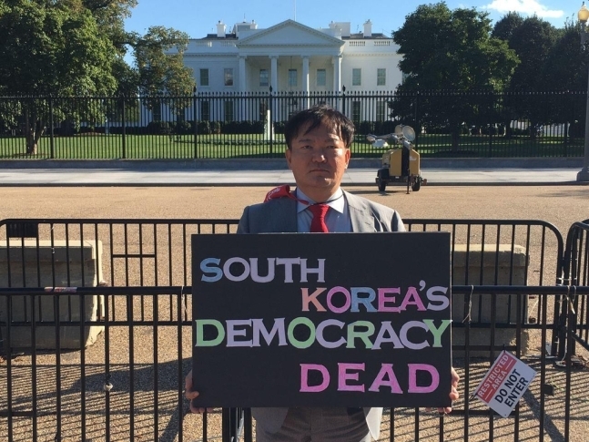 국민의힘 민경욱 전 의원이 지난 2일 자신의 페이스북에 미국 백악관앞에서 ‘한국의 민주주의는 죽었다’며 부정선거를 규탄하는 피켓시위를 펼치는 모습을 소개했다. 민 전 의원 페이스북 캡처