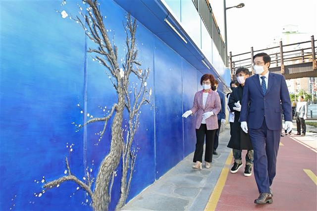 이동진(맨 앞) 도봉구청장이 서울 도봉구 방학천 문화예술거리에 조성된 ‘천년 매화도’를 감상하며 걷고 있다. 도봉구 제공