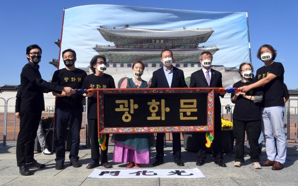 574돌 한글날을 하루 앞 둔 8일 서울 광화문 앞에서 광화문현판훈민정음체로시민모임 소속 회원들이 훈민정음체 한글로 적힌 광화문 현판을 들어보이는 퍼포먼스를 하고 있다.2020. 10. 8 정연호 기자 tpgod@seoul.co.kr