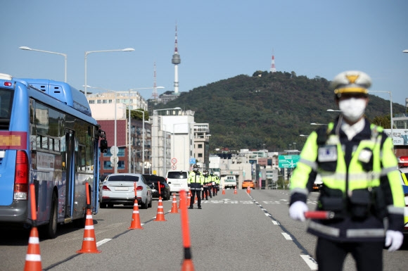 9일 오전 서울 한남대교 북단에서 경찰이 차량을 검문하고 있다. 한글날이자 연휴의 시작인 이날 서울 도심에서 일부 단체가 예고한 대규모 집회는 금지됐지만 기자회견이나 차량시위 등은 진행될 것으로 보여 방역당국과 경찰이 긴장하고 있다.  연합뉴스