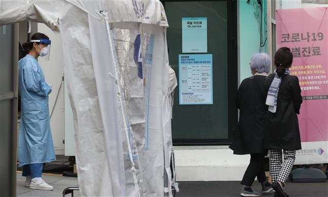 13일 오후 서울 중구 국립중앙의료원에 마련된 선별진료소에서 의료진들이 내원객들에게 코로나19 검사 안내를 하고 있다. 2020.10.13 뉴스1