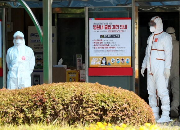 코로나19 확진자가 29명 무더기로 발생한 경기 광주시 SRC재활병원에서 17일 오후 방역복을 입은 관계자가 분주하게 움직이고 있다. 연합뉴스