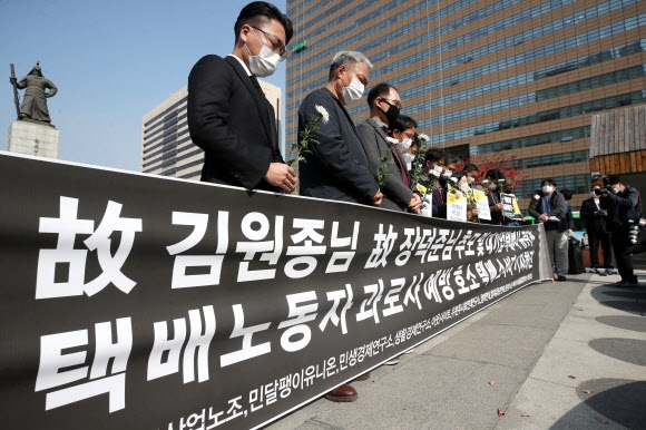 19일 오후 서울 광화문광장 이순신 동상 앞에서 열린 ‘대기업 택배사 규탄과 택배노동자 과로사 예방 호소하는 택배 소비자 기자회견’에서 참석자들이 묵념을 하고 있다. 연합뉴스