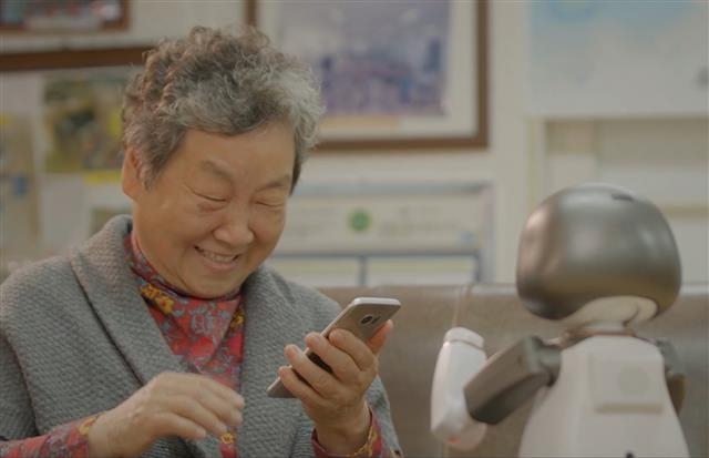 인공지능(AI) 로봇인 리쿠가 한 노인에게 스마트폰 활용 방법을 교육하고 있다. 관악구 제공