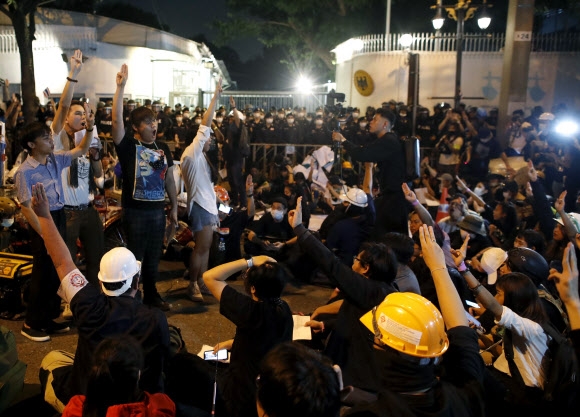 태국 반정부 시위대가 26일 밤 수도 방콕의 독일대사관 앞에서 마하 와치랄롱꼰 국왕의 현지 체류 내역 조사를 독일 정부에 촉구하며 저항의 상징인 ‘세 손가락 경례’를 하고 있다. 방콕 EPA 연합뉴스