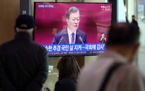 28일 서울역을 찾은 시민들이 TV 화면을 통해 문재인 대통령의 국회 시정연설 장면을 지켜보고 있다. 연합뉴스