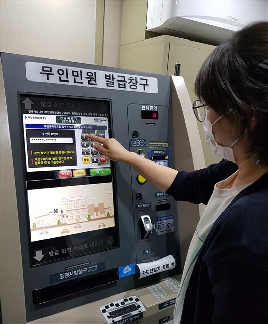 2일 서울 중구의 한 동주민센터에 설치된 무인민원발급기에서 한 주민이 민원서류를 발급받고 있다. 중구 제공