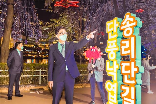 박성수(가운데) 송파구청장이 지난달 30일 서울 송파구 석촌호수 동호 일대에서 열린 ‘2020 석촌호수 단풍&낙엽축제’ 점등식에 참석해 직접 축제 현장을 둘러보고 있다. 송파구 제공