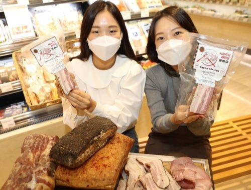 서울 중구 롯데백화점 본점 식품관에서 직원들이 사실주의베이컨 상품을 들고 포즈를 취하고 있다.