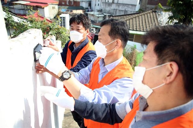 이승로(왼쪽 두 번째) 성북구청장이 서울 성북구 장수마을에 태양광 센서등을 설치하고 있다. 성북구 제공