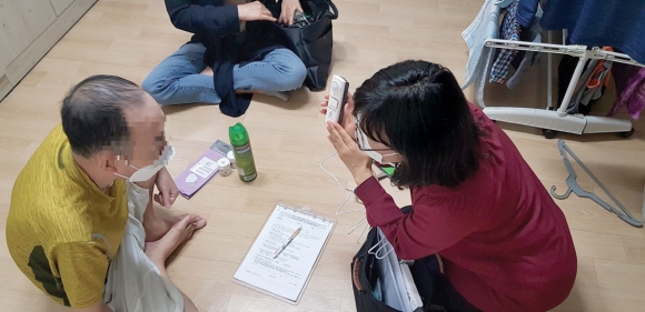 강서구 복지플래너가 중장년 1인 가구를 방문해 사물인터넷(Iot) 기술을 이용한 스마트 플러그 사용법에 대해 설명하고 있다. 강서구 제공