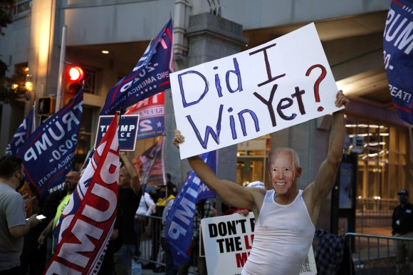 5일(현지시간) 펜실베이니아주 필라델피아에서 도널드 트럼프 대통령 지지자가 조 바이든 후보의 가면을 쓰고 있다. AP