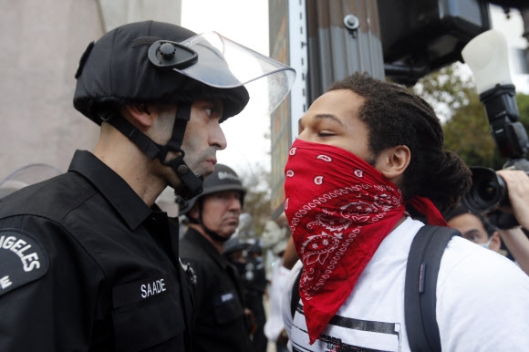 6일(현지시간) 캘리포니아주 로스앤젤레스에서 한 시위자가 경찰과 마주보며 대치하고 있다. AP