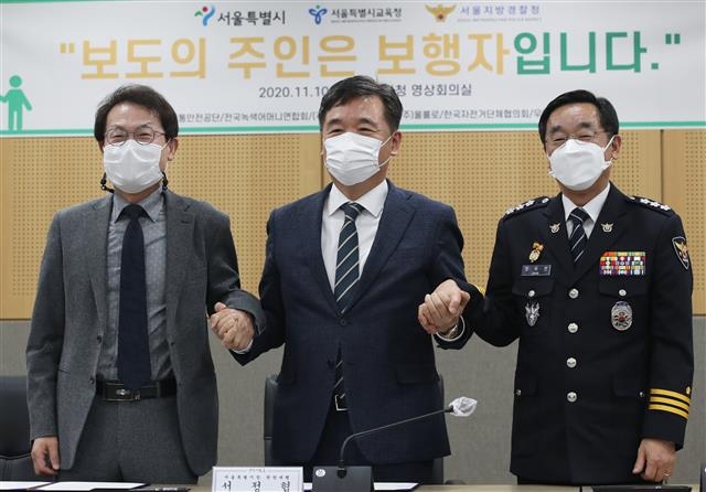 서정협(가운데) 서울시장 권한대행과 조희연(왼쪽) 서울시교육감, 장하연 서울지방경찰청장이 10일 서울시청에서 열린 ‘보행안전 공동협력 협약식’에서 기념 촬영을 하고 있다. 뉴스1