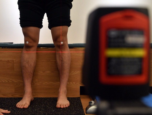 깔창 제작업체를 찾은 인터스키 국가대표 데몬스트레이터 김하영 선수가 레이저 포인터를 이용해 족적이 무릎에 미치는 영향을 측정하고 있다.