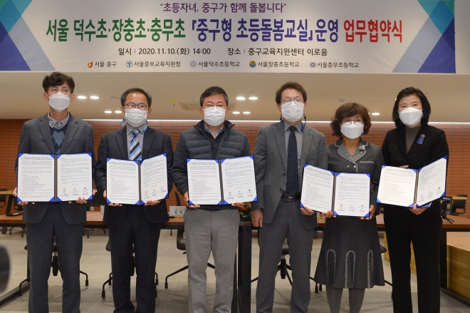 지난 10일 서울 중구교육지원센터 ‘이로움’에서 열린 중구형 초등돌봄교실 운영 업무협약식에서 서양호 중구청장(왼쪽에서 세번째), 조희연 서울교육감(왼쪽에서 네번째) 등 주요 참석자들이 서명된 협약서를 들어보이고 있다. 2020.11.13. 중구 제공 