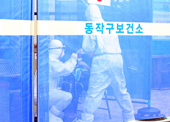 서울 동작구보건소 선별진료소에서 13일 코로나19 검사를 실시하고 있다.