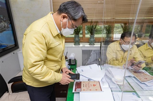 김선갑 서울 광진구청장이 지난 16일 구청장실에서 QR코드를 사용해 ‘2021 희망온돌 따뜻한 겨울나기 사업’에 참여하고 있다. 광진구 제공