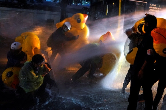 태국 방콕의 반정부 시위대가 17일 오리 모양의 대형 튜브로 경찰의 물대포 진압을 막고 있다. 방콕 로이터 연합뉴스