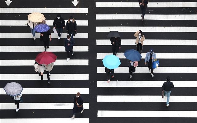 비가 내린 18일 오후 서울 강남구의 한 횡단보도 위로 우산 쓴 시민들이 지나가고 있다. 2020.11.18 뉴스1