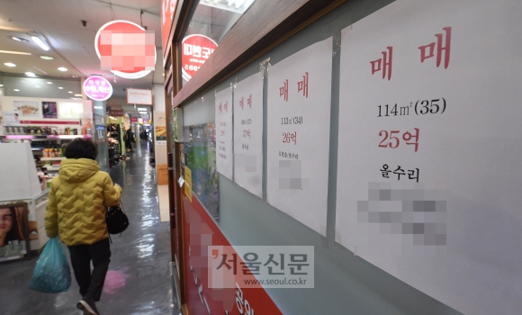 공시가격이 크게 오르면서 이를 반영한 종부세고지서가 배달된 가운데 24일 서울 강남의 한 아파트 부동산 앞에 붙은 시세판 앞으로 한 시민이 지나가고 있다. 2020. 11. 24 정연호 기자 tpgod@seoul.co.kr