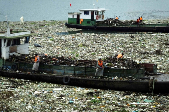 양쯔강에 쌓인 쓰레기 더미 치우는 중국 인부들