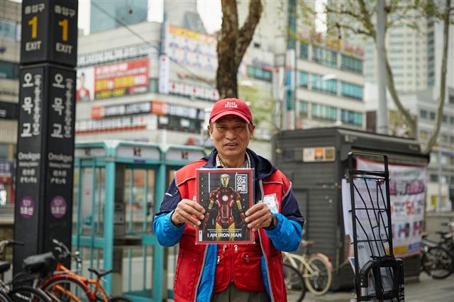 서울 양천구 오목교역 앞에서 빅이슈코리아 판매원이 매거진 ‘빅이슈’를 들고 웃고 있다. 빅이슈코리아 제공