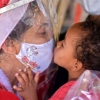 [포토] 비닐 장막 사이 두고 자원봉사자와 감사 키스하는 브라질 어린이