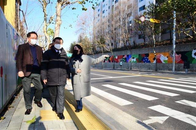 류경기(가운데) 서울 중랑구청장이 지난 9일 구청 관계자들과 함께 중랑구 신내5단지 아파트 옹벽 벽화를 둘러보고 있다. 중랑구 제공
