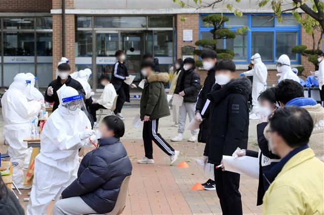 10일 오후 광주 광산구 한 고등학교에서 학생들이 신종 코로나바이러스 감염증(코로나19) 진단 검사를 받고 있다. 광주시에 따르면 전날 해당 학교 교사 1명이 확진 판정을 받아 방역당국이 임시 선별진료소를 설치, 재학생과 교직원 등 400여명에 대한 검체 채취를 진행 중이다.2020.12.10 뉴스1