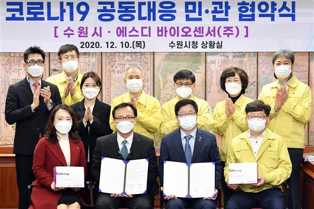 염태영(앞줄 왼쪽 세 번째) 수원시장과 이효근(두 번째) SD바이오센서 대표가 10일 시청 상황실에서 코로나19 공동 대응을 위한 업무협약을 체결한 뒤 기념 촬영을 하고 있다. 수원시 제공