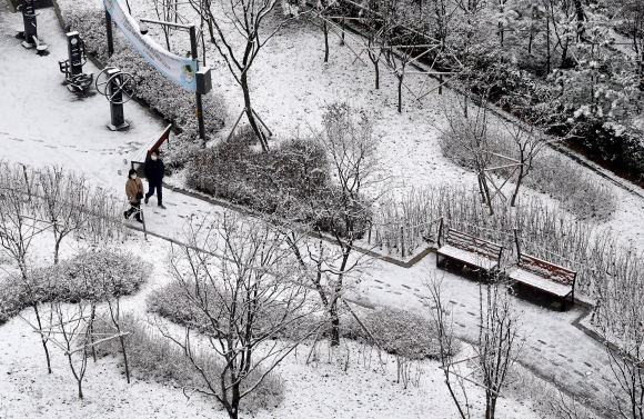 서울에 폭설이 내린 13일 반포의 한 아파트공원에서 시민들이 눈이 쌓인 거리를 걷고 있다.  2020.12.13 박지환 기자 popocar@seoul.co.kr