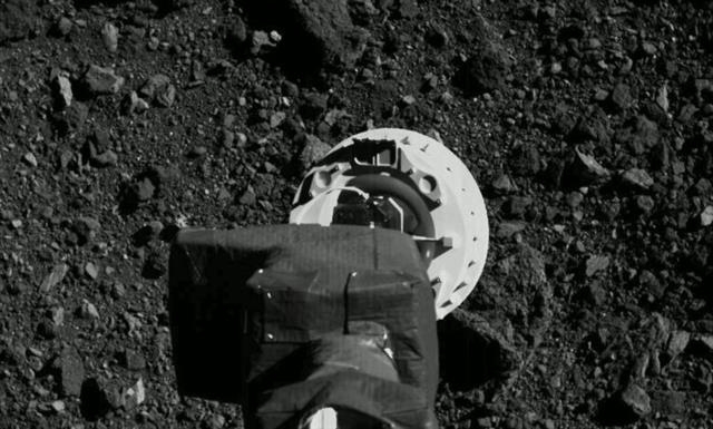 오시리스·렉스호가 소행성 베누 표면에서 암석 표본을 채취하는 모습.  NASA 제공