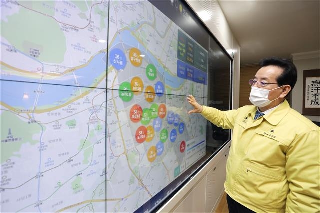 지난 14일 정순균 서울 강남구청장이 새로 도입한 스마트강남 구청장실 시스템을 활용해 코로나19 상황을 파악하고 있다. 정 구청장은 이 시스템을 내년에는 구민들도 이용할 수 있게 업그레이드할 계획이다. 강남구 제공