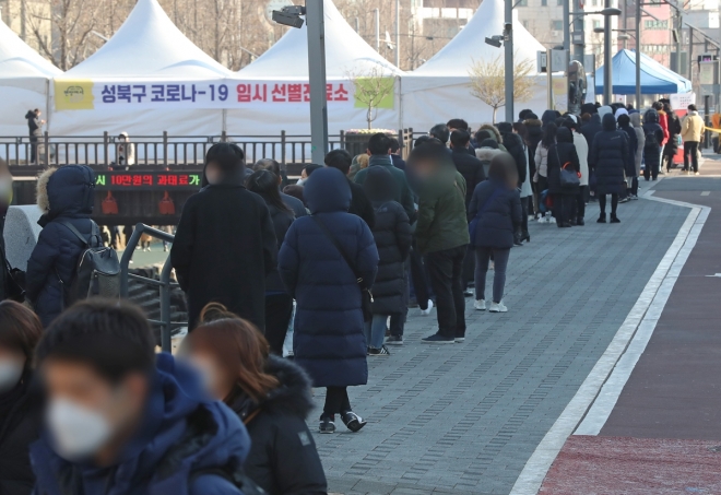 18일 오후 서울 성북구청 앞 임시 선별진료소에서 시민들이 코로나19 검사를 받기 위해 차례를 기다리고 있다. 2020.12.18  연합뉴스