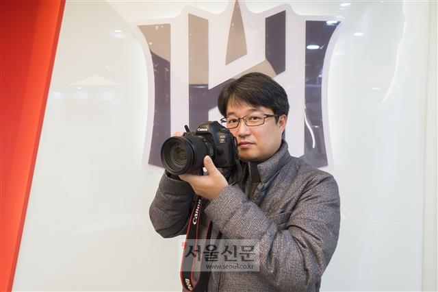 프로야구 kt 위즈 전속 사진작가 지용현씨가 지난 22일 수원kt위즈파크에서 서울신문과 인터뷰하며 자신의 카메라로 사진 찍는 포즈를 취하고 있다.