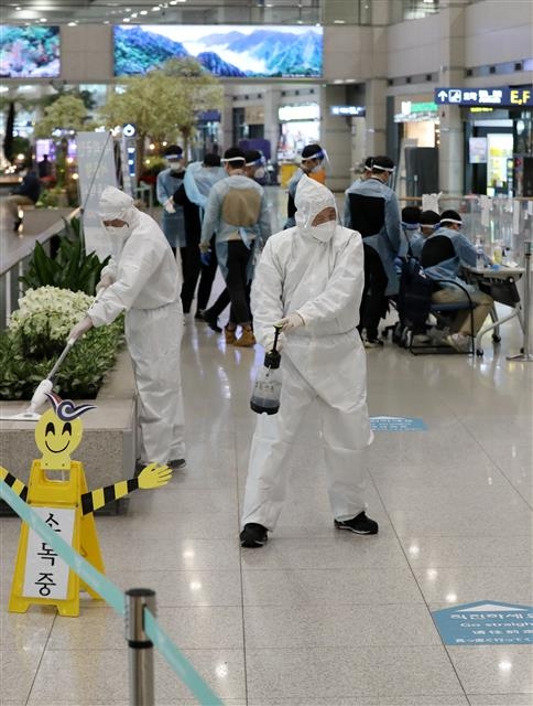 28일 인천국제공항 제1여객터미널 입국장에서 공항 방역요원들이 방역작업을 하고 있다. 이날 중앙방역대책본부는 지난 22일 영국에서 입국한 사례에서 코로나19 변이 바이러스를 확인했다고 발표했다. 뉴스1