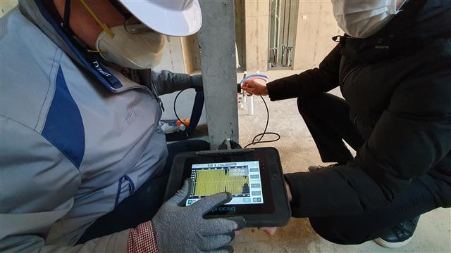 삼성물산 관계자들이 한 아파트 공사현장에서 소음 방지 설계를 위해 기기로 수치를 측정하고 있는 모습. 삼성물산 제공