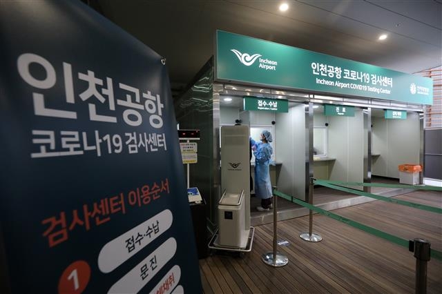 30일 인천국제공항 제2여객터미널 지하 1층 서편 외부 공간에 마련된 코로나19 검사센터에서 의료진이 접수한 시민의 체온을 측정하고 있다. 뉴스1