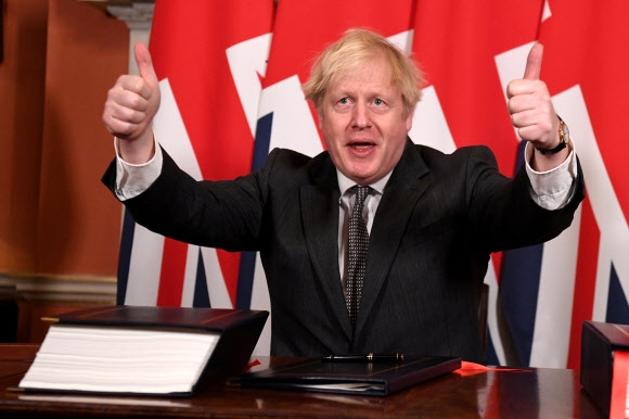 보리스 존슨 영국 총리가 30일(현지시간) 런던 총리관저에서 EU와의 미래관계 협상 합의안에 서명한 뒤 엄지를 들어 보이고 있다. 런던 로이터 연합뉴스