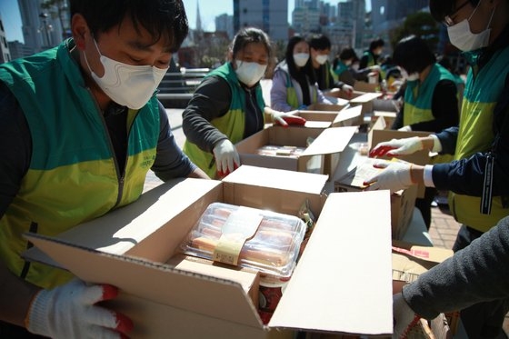 지난 3월 11일 부산 동구청 광장에서 자원봉사자들이 취약계층에 전달할 긴급지원물품을 포장하고 있다/초록우산어린이재단]