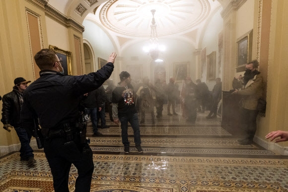 연기 자욱한 의사당 안에서 경찰과 대치한 트럼프 지지자들