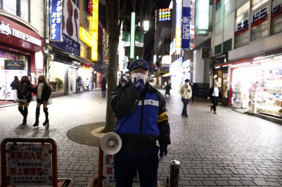 코로나19 긴급사태 선언 첫날 외출 자제 당부하는 일본 경찰관