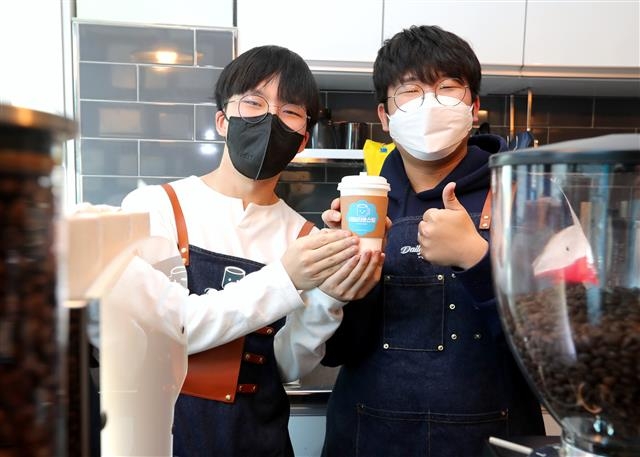 서울 금천구의 학교 밖 청소년들로 구성된 협동조합 ‘원두’의 조합원이자 로스팅 매니저인 김종현(왼쪽)씨와 이사장인 채석진씨가 “카페 ‘데일리 로스팅’이 다른 청소년들에게도 의미 있는 공간이 되기를 바란다”며 엄지를 치켜세우고 있다. 금천구 제공