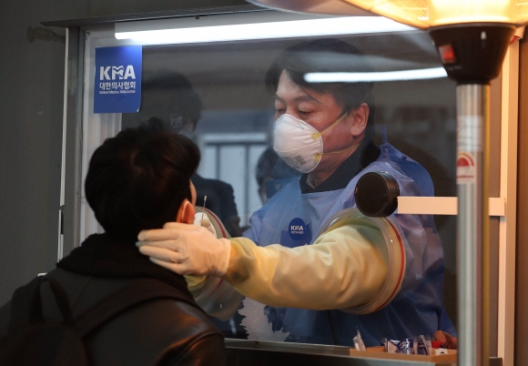 안철수 국민의당 대표가 15일 오전 서울광장에 마련된 임시 선별검사소에서 검체를 채취하는 의료자원봉사를 하고 있다.국회사진기자단