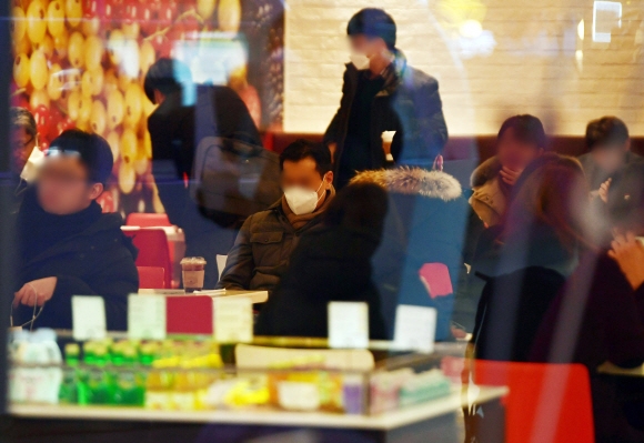 수도권 지역 카페와 실내 체육시설, 노래 연습장 등 다중이용시설 운영이 재개된 18일 서울역 한 카페에서 시민들이 매장에 앉아 커피를 마시고 있다.  2021. 1. 18 박윤슬 기자 seul@seoul.co.kr