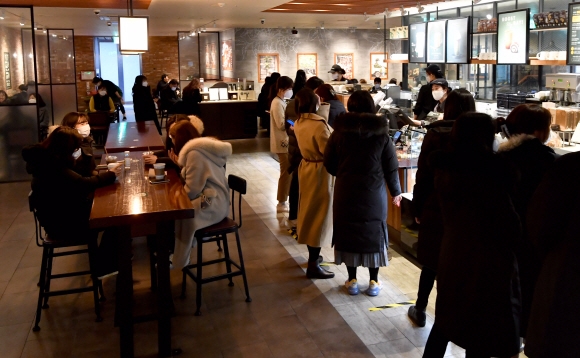 카페, 헬스장 등 다중이용시설에 대한 방역조치가 일부 완화된 18일 서울 시내 한 커피전문점을 찾은 시민들이 지인들과 자리에 앉아 음료를 마시며 이야기하고 있다. 박지환 기자 popocar@seoul.co.kr