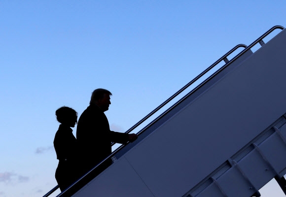 20일(현지시간) 4년간의 백악관 생활을 마친 도널드 트럼프 전 미국 대통령과 부인 멜라니아가 앤드루스 공군기지에서 플로리다로 향하는 비행기에 오르고 있다. 로이터 연합뉴스